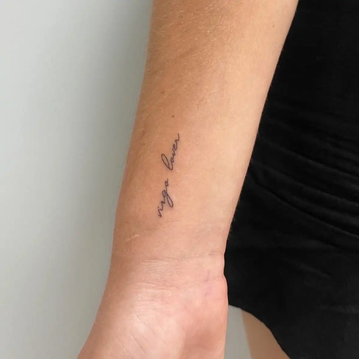 Tatuaje pequeño de lettering fino en el antebrazo